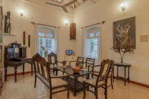 a dining room with a table and chairs and a piano at Phoenix by Hireavilla 5BR Villa with Pool in Colvale in Colovale