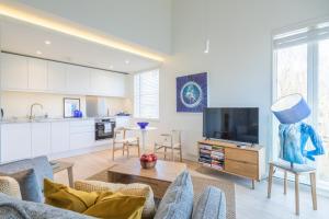 a living room with a couch and a tv at Luxury City Centre Apartment - Stunning Water View in Cambridge