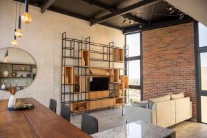 a living room with a table and a brick wall at Depto de lujo en zona Carmelitas in Asuncion