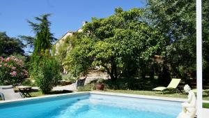 een zwembad voor een tuin met bomen bij La belle histoire gîte Luberon in Bédoin