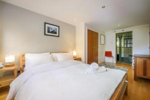 a bedroom with a large white bed with towels on it at Large Luxurious CENTRAL Private Terrace - For 6 in London