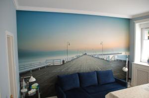 una sala de estar con una pintura de un muelle en Apartament 200 m od morza, en Sopot