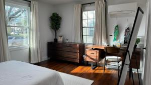 a bedroom with a desk and a bed and a chair at Garden District Duplex in Baton Rouge