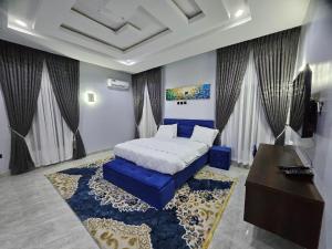 アブジャにあるJazeera Apartmentsのベッドルーム1室(ベッド1台、テーブル、青いソファ付)