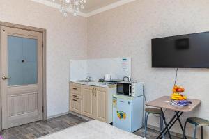 a small kitchen with a refrigerator and a small table at YourHouse Микрорайон Жетысу-2, дом 66 in Almaty