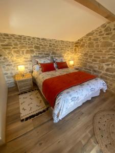 a bedroom with a bed and a stone wall at Le Mas Vivarés in Lablachère +39 photos