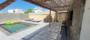 une terrasse avec une piscine et un parasol dans l'établissement Villa individuelle 3 chambres - 6 pers, à Calvi