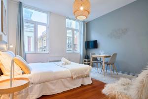 een slaapkamer met een bed en een tafel met stoelen bij Fully equipped studio near Grand Place in Lille