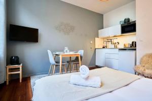 een kamer met een bed en een keuken met een tafel bij Fully equipped studio near Grand Place in Lille +13 foto's