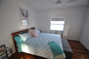 1 dormitorio con cama y ventana en Sunset Beach House 1770 Level 2, en Seventeen Seventy
