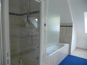 W łazience znajduje się prysznic i wanna. w obiekcie Maison d'Hôtes le Clos Spinoza w mieście Saint-Planchers