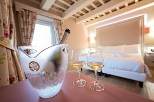 MontegiorgioにあるOfficina del Soleのホテルの部屋のテーブルにワイン1本とグラス2杯