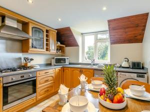 a kitchen with a table with a bowl of fruit on it at 4 Bed in Barnstaple ELLER in Fremington