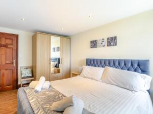a bedroom with a large bed with a blue headboard at 4 Bed in Barnstaple ELLER in Fremington