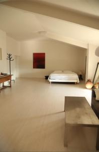 Un dormitorio con una cama en el medio de una habitación. en Commanderie Vue Panoramique 2 chambres, en Le Poët-Laval