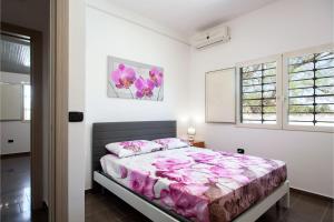 a bedroom with a large bed with pink sheets at Villa Sabbia Magica 100 meters from sea - Happy Rentals in Porto Cesareo