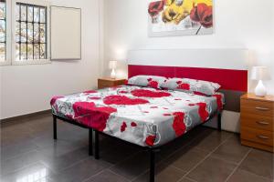 a bedroom with a bed with a red and white comforter at Villa Sabbia Magica 100 meters from sea - Happy Rentals in Porto Cesareo