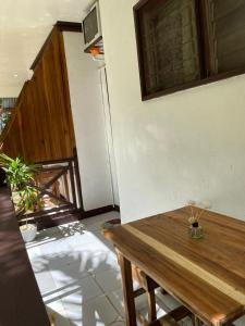 a room with a wooden table and stairs at Aquaholik Traveler's Lodge in El Nido