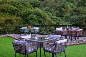 a group of tables and chairs on the grass at French Villa I Luxury I 3BHK Villa I Kasauli I 87oo2o5865 in Kasauli