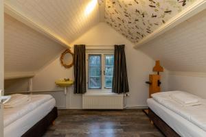 een kamer met 2 bedden en een raam bij Vakantievilla - Valkenisseweg 68 - Biggekerke 'Strand Villa' in Biggekerke