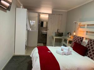 een slaapkamer met een bed met twee handdoeken erop bij Meraki Upmarket Guesthouse in Rustenburg