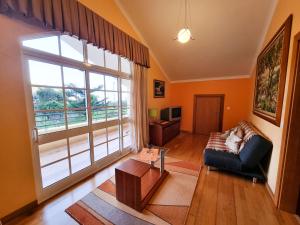 sala de estar con sofá y ventana grande en Villa Atlântico, en Ponta do Sol