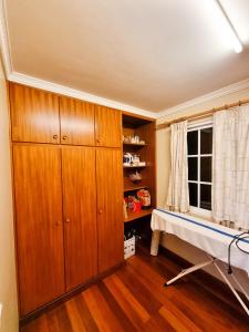 a bedroom with wooden cabinets and a table in a room at Villa Atlântico in Ponta do Sol