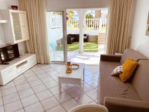 a living room with a couch and a tv at Bungalow Monte Golf in Playa del Ingles