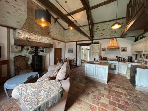 a large living room with a couch and a kitchen at Petit Clos Gîte Rural in Saint-Jean-de-Duras