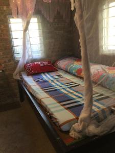 a bed with a canopy in a room with windows at Sue Pa Family Trekking Homestay in Sa Pả