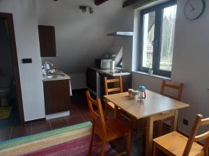Olesiówka في Nowinka: مطبخ صغير مع طاولة وكراسي خشبية