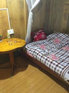 a bed and a table in a room at Sue Pa Family Trekking Homestay in Sa Pả