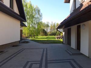 einen Gang zwischen zwei Gebäuden mit einem Park im Hintergrund in der Unterkunft Olesiówka in Nowinka