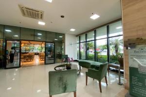 un hall avec des chaises et des tables vertes dans un bâtiment dans l'établissement Duplex Luxo Hotel Athos Bulcão Brasília - Ozped Flats, à Brasilia