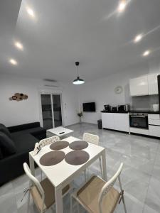 eine Küche und ein Wohnzimmer mit einem Tisch und Stühlen in der Unterkunft Hana Holiday Beach Apartment 1 in Artemida