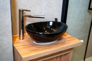a black bowl sink sitting on top of a wooden counter at Julys Apartment Nr 3 in Oberhausen