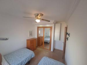 Schlafzimmer mit einem Bett, einer Kommode und einem Spiegel in der Unterkunft Los Juncos II, apartamento in Maspalomas