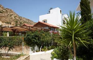 a house with a palm tree in front of it at Elea Terra Hotel in Matala