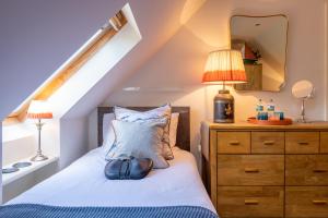 a bedroom with a bed and a dresser with a mirror at 5-STAR LUXURY on MILLSTREAM near SEA, OLD BOSHAM in Bosham