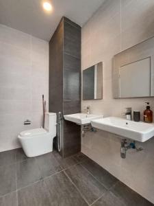 a bathroom with two sinks and a toilet and a tub at The Penthouse TROIKA KOTA BHARU in Kota Bharu