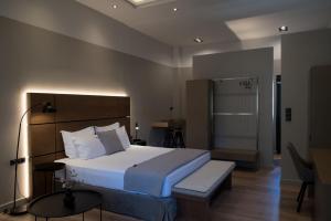 a bedroom with a bed and a table and a lamp at ILION Air Host - near Athens International Airport in Markopoulo