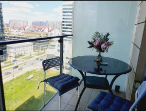a table and chairs in a room with a window at CityHome Platinum Towers in Warsaw