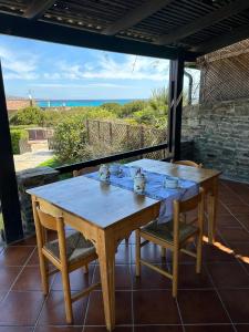 a wooden table and chairs on a patio with the ocean at Malv House in Stintino