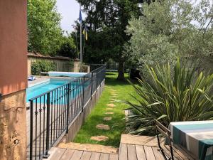 una piscina con una valla junto a un patio en Chambre et Petit-déjeuner à Collonges au Mont d'Or en Collonges-au-Mont-dʼOr
