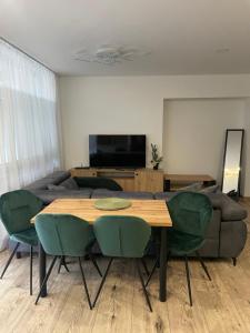a living room with a table and green chairs at Rado Apartments in Svit