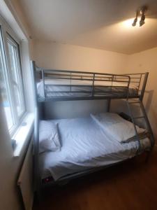 倫敦的住宿－Beautiful 3-Bed House in London，一间卧室设有两张双层床和一扇窗户。