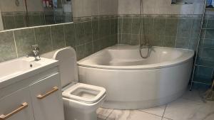 La salle de bains est pourvue d'une baignoire, de toilettes et d'un lavabo. dans l'établissement Beautiful 3-Bed House in London, à Londres