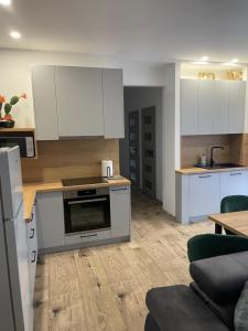 a kitchen with white cabinets and a stove top oven at Rado Apartments in Svit