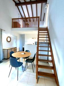 a room with a table and chairs and a staircase at Résidence Les Cigales in Porto-Vecchio