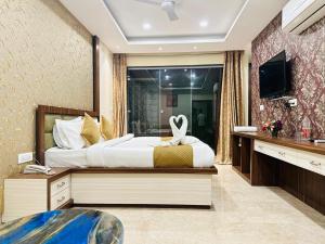 a bedroom with a large bed and a tub at Hotel Fortune Ganga in Haridwār